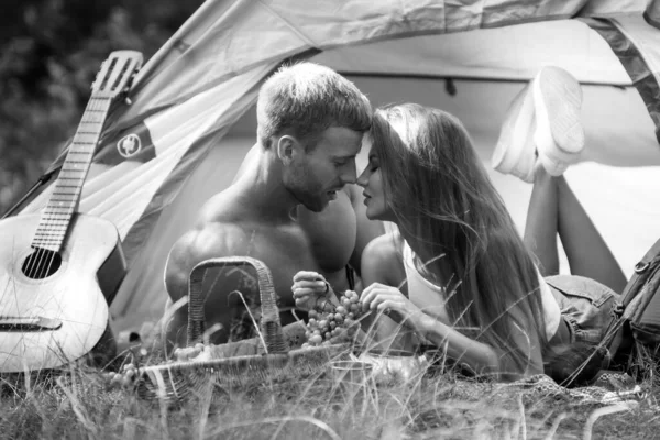 Romantic couple camping on nature background. Adventure for young friends on summer day. Young couple in love hug each other. Sexy couple travel kissing on holidays camp