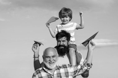 Mutlu gülümseyen çocuk, baba kameraya bakıyor. Erkek çoklu nesil portresi. Baba ve büyükbaba ile çocuk