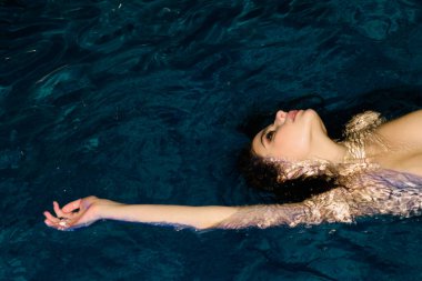 Havuzda yüzen çıplak seksi bir kız. Kadınlar yaz plajlarında rahatça yüzerler. Çıplak kadın vücudu. Romantik hassas kız arkadaş. Lüks, büyüleyici, güzel bayan.