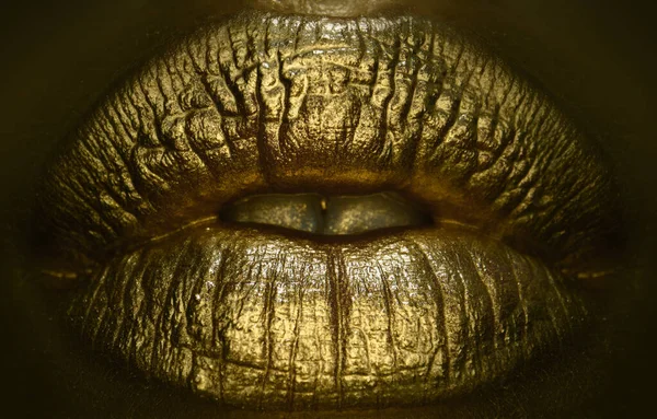 Golden lipstick closeup. Lips with metal makeup. Sexy lips, Metallic lipstick close up. Art design make up