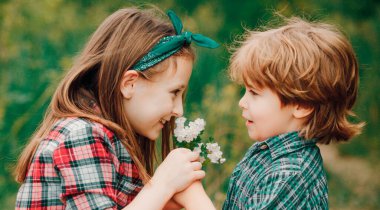 Bahar çocuğu suratlı pankart. Birbirini seven küçük bir çift birbirinin yüzüne üflüyor.