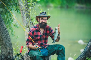 Oltayla olta atan adam, nehir suyunda balıkçı. Yaz balıkçılık hobisi