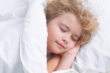 Kid enjoying sweet dreams. Little boy sleeping in bed. Cute kid sleeping well alone in bed under blanket. Kid lying on pillow, adorable small child rest asleep, enjoy good healthy sleep or nap