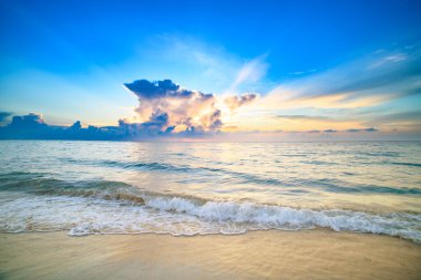 Sunset sea landscape. Colorful beach sunrise with calm waves. Nature sea sky. Seascape in summer morning. Sunrise with clouds of different colors against the blue sky and sea