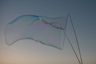 Dev renkli baloncuk. Mavi gökyüzünde büyük bir sabun köpüğü. İple kocaman sabun köpükleri. Sopalar mavi gökyüzüne karşı büyük kabarcıklar oluşturuyor. Halat ve sopalarla kabarcık oluşturur.