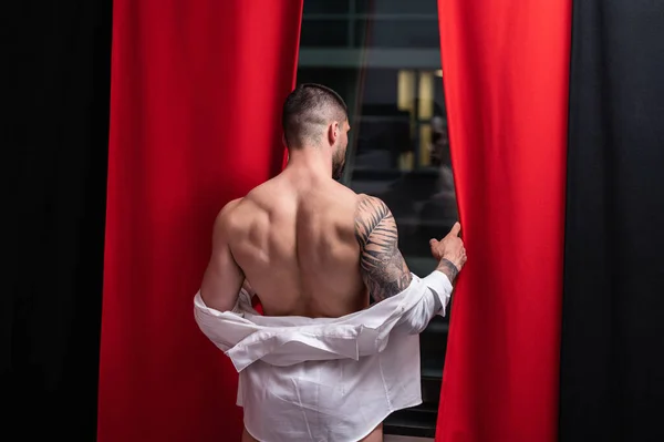 裸の体 筋肉の肩を持つ男 ベッドで裸の男 筋肉のセクシーな男性の体 ゲイのセクシーなモデル 窓のカーテンの近くに裸の胴を持つ筋肉のセクシーな男 運動体とハンク 夜を楽しむ男 — ストック写真