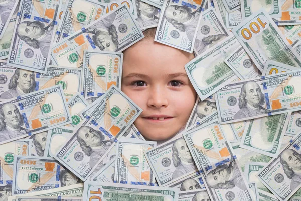 Money banknotes, cash dollars bills. Child head in money. Fun kid face on dollars money