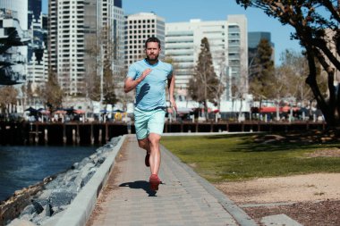 Athletic young man running in the nature. Run in city park