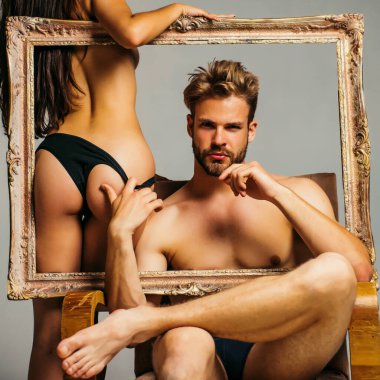 Güzel bir kadın boş bir çerçeve tutuyor. Acımasız yakışıklı erkek model. Genç bir çiftin hassas bir fotoğrafı. - Genç. Baştan çıkarıcı üstsüz kadın ve erkek. Cinsel olarak çok açık. Seksi çift aşk oyunlarında oynar. Moda.