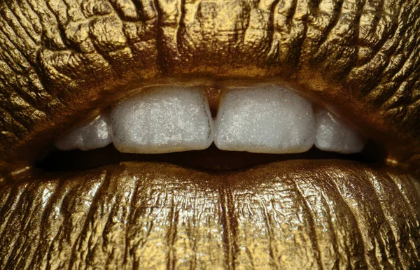 Golden lips macro close up. Lip icon with golden glitter effect. Sensual mouth. Symbol of kiss from golden lipstick. Glamour luxury gold mouth