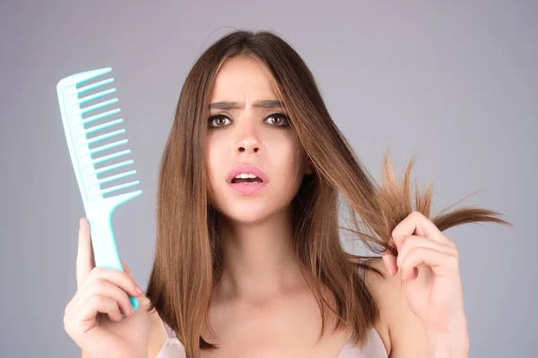 Hair loss woman with a comb and problem hair. Hairloss and hairs problems. Sad girl with damaged hair. Haircare and loss hair problem. Tangling hairs. Girl combing damaged hairs. Alopecia, dandruff