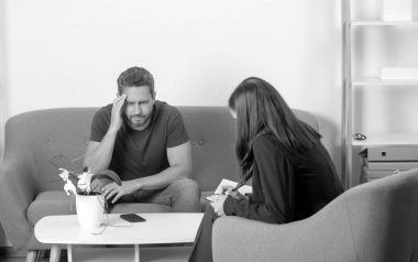 Psikolog, genç adamın erkek sorunlarını çözmesine yardım ediyor. Bunalımlı orta yaşlı adam sorunu terapisi. Psikolojik sorun, terapi.