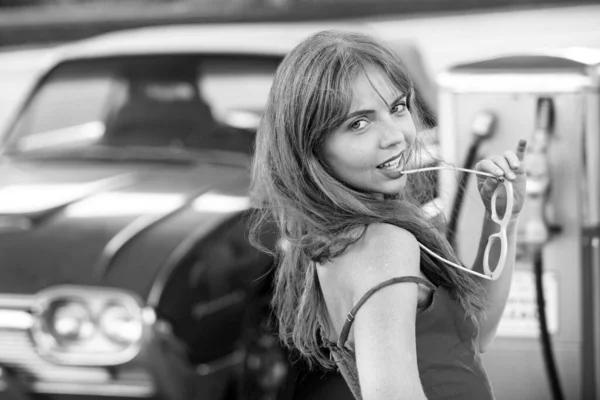 きれいな女性が車を給油する ガソリンスタンドだ 赤のレトロな自動車に対するエレガントな女性 — ストック写真