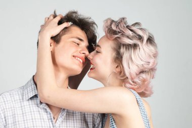 Stüdyoda sarılıp kucaklaşan genç ve güzel bir çift. Birbirine aşık genç, güzel bir çift. Sevgi. Mutlu mutlu bir çift portresi. Moda. Kapatın. Neşeli bir şekilde gülümse iyi ilişkiler kur.