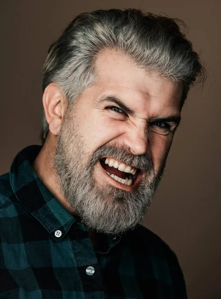 Angry Man. Portrait of a happy man over gray background. Fashion style portrait of handsome guy. Handsome young man on grey background looking at camera