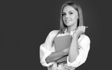 Sınav hazırlayan ve okulda ders öğrenen öğrenci. Kalem ve kitapla gülümseyen yaratıcı genç bayan öğrenci.