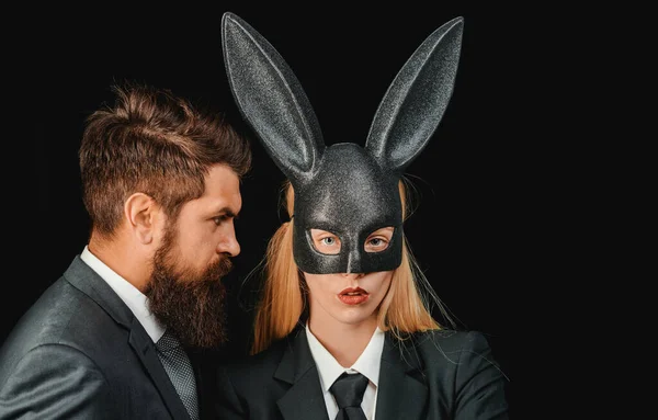 面白い髭の男とカーニバルウサギのマスクの女性 ウサギの耳の中に甘い素敵な魅力的な愛らしい陽気な肯定的な女の子 隔離された黒の背景 — ストック写真