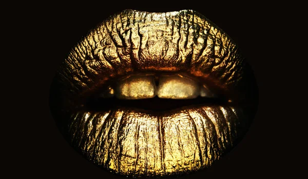 Gold lips, golden gloss lipstick. Gold lips. Gold paint from the mouth. Golden lips on woman mouth with make-up. Sensual and creative design for golden metallic