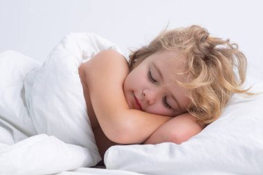 Kid sleeping in cozy white bed. Kid sleeping on bed at home. Bedtime, kids sleeps. Child asleep on pillow, having healthy sleep