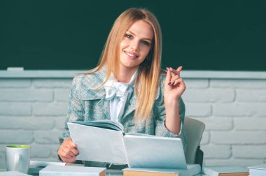 Lise öğrencisi elinde İngilizce ya da matematiği öğrenen bir kitap tutuyor.