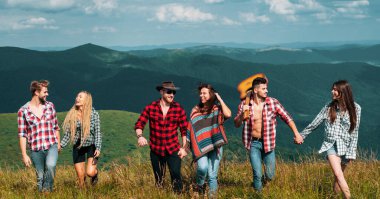 Dağda yürüyen mutlu arkadaşlar. Hafta sonu yürüyüşü. İnsanlar güneşli bir günde pikniğin tadını çıkarıyorlar. Yaz tatilleri