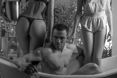Banyodaki seksi adam şarap içiyor. Üçlü konsept. Küvette üç kişi birlikte. Eş değiştirme, seks partisi ya da banyoda üçlü seks. Biseksüel kadın. Cinsel fantezi
