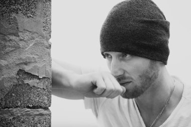 Gri arka plandaki yakışıklı genç adam kameraya bakıyor. Yakışıklı bir adamın portresi, arka planı gri ve fotokopi alanı var.