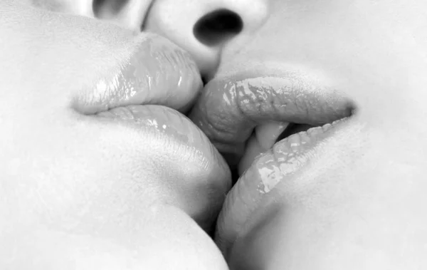 Kissing close up. Sexy plump lips without makeup. Two beautiful sexy lesbians in love. Passion and sensual kiss. Homosexual couple close up