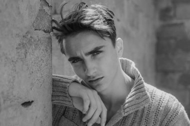 Gri arka planda genç adamın yakın çekimi. Erkek moda konsepti