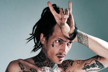 Boynuz işareti. Yakışıklı, dövmeli adam. Erkekler dövme modası. Acımasız adam.