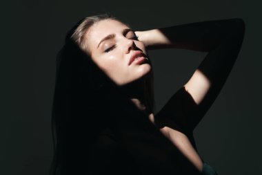 Çekici ve şehvetli görünen güzel kadın modelinin portresi. Sanat gölgesi ışığı olan şehvetli bir kız. Siyaha izole edilmiş dramatik stüdyo ışığı olan güzel bir yüz.