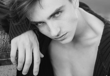 Ahşap arka planda yakışıklı bir genç adam kameraya bakıyor. Erkek moda konsepti