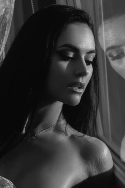 Sensual lady with bare chest near mirror or window with makeup. Naked female woman body