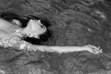 Havuzda yüzen çıplak seksi bir kız. Kadınlar yaz plajlarında rahatça yüzerler. Çıplak kadın vücudu. Romantik hassas kız arkadaş. Lüks, büyüleyici, güzel bayan.