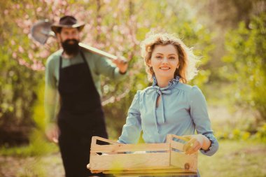 Country life. Portrait of wife and husband while working in garden. Bio food production concept. Spring gardening routine