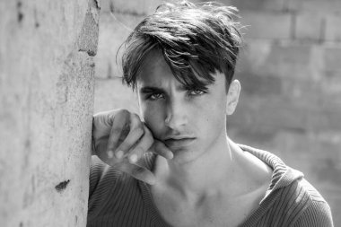 Erkek yüzü. Gri arka planda izole edilmiş, düşünen bir adamın portresi. Bıyıklı ve sakallı ciddi bir erkek modelin yakın plan portresi.