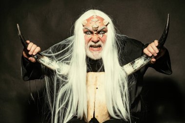 Siyah arka planda bir Druid. Ejderha derisi ve gri sakallı bir uzaylı. Eski simya. Beyaz mavi gözlü canavar. Ağaç ruhu ve fantezi konsepti. Boynuzlu kötü adam