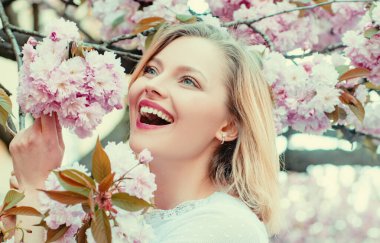 The idea and concept of happy women on International Womens Day. Happy woman with blooming Sakura tree and sunny day