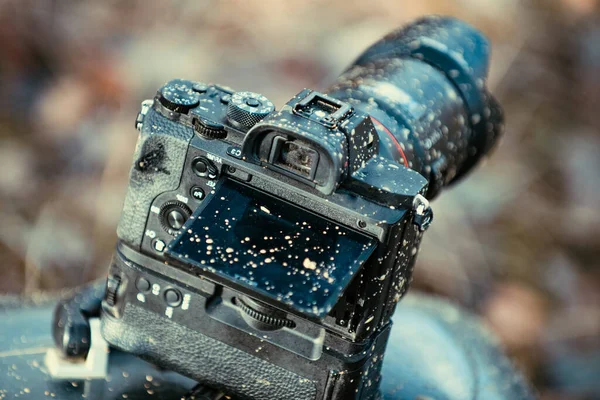 A dirty photo camera lens isolated on nature. Macro. Dustproof moisture protection. Close up dust and dirt on a camera lens. Macro view. Interchangeable lens camera with a sleek design