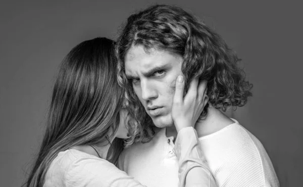 Attractive young couple hugging each other on grey background. Young man and woman in cuddle. Young sexy couple. Close up photo. Love and trust. Pose for family portrait. Love