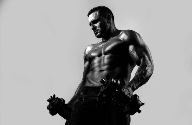 Mavi neon üzerinde izole halterlerle egzersiz yapan kaslı vücut geliştirici adam. Fitness adamı. Yakışıklı, kaslı, beyaz tenli yakışıklı. Mavi arka planda izole edilmiş kollarıyla antrenman yapıyor.