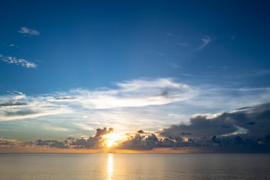 Sunset on sea background. Nature wallpaper with summer sea. Water sea texture. Calm sunrise on tropical sea. Beautiful sky, amazed clouds