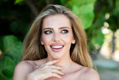 Beautiful woman enjoying summer. Fashion vogue style closeup portrait. Fashion model on spring nature background. Charming fashionable woman with perfect skin, makeup and long blonde hair