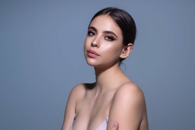 Youth and skin care concept. Photo of sensual model isolated on studio background. Close up portrait of beautiful woman with soft clean pure skin. Beauty face of young woman with red lipstick on lips