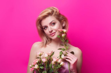 Romantic dating or proposal. Love and dating. Pretty woman, with red lips, and fashion makeup with roses posing in studio. Beauty and fashion portrait