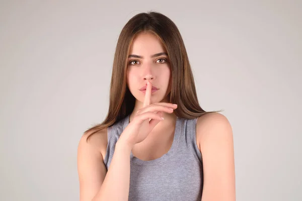 Say secret hush be quiet with finger on lips. Shhh gesture isolated on studio background portrait. Girl showing hush. Woman say secret hush be quiet with finger on lips, shhh gesture
