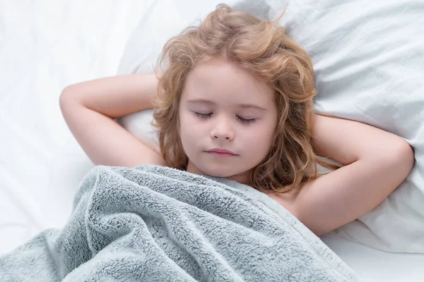 Kid enjoying sweet dreams. Lovely face of blonde caucasian child, sleeping on bed. Sweet dreams. Little baby boy sleeping while lying on bed at home