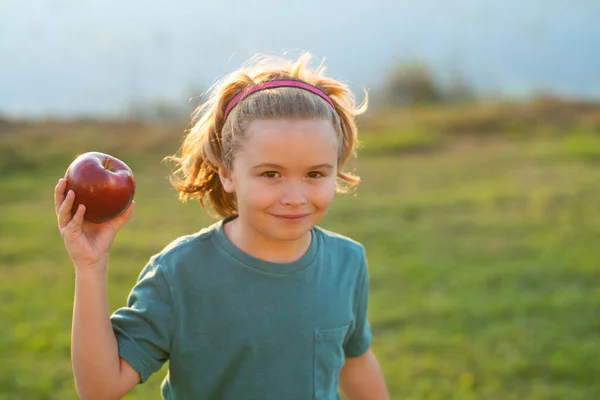 Kid eat apple. Child nutrition. Portrait of happy smiling child boy with apples outdoor