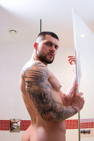 浴室でシャワーを浴びているセクシーな筋肉の男 裸の体を洗うセクシーな男 男性のボディケア 美容ルーチンと毎日の衛生 浴室で裸の胴とのゲイ 朝のルーティン 朝は新鮮 — ストック写真