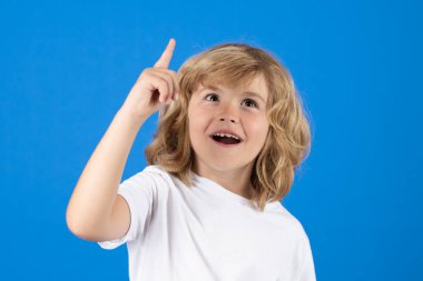 Excited child boy have idea on studio isolated background. Surprised face, amazed emotions of child. Portrait of school kid with finger pointed up